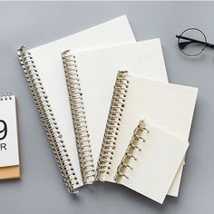 notebooks and eyeglasses on a table next to a calendar with the number 99