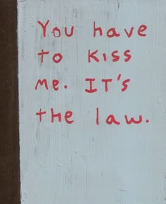 graffiti written on the side of a building that says, you have to kiss me it's the law