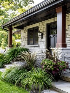 a house with some plants in front of it and grass on the ground next to it