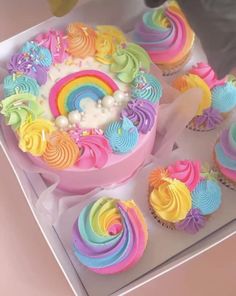 cupcakes decorated with rainbow icing in a box