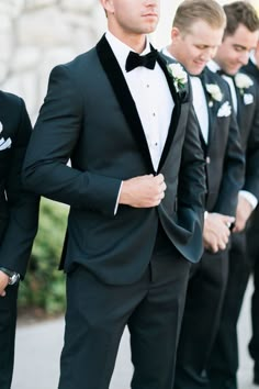 a group of men in tuxedos standing next to each other