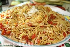 a plate of spaghetti with tomatoes and parmesan cheese on top, ready to be eaten