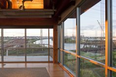 an empty room with lots of windows overlooking the water and bridge in the distance,