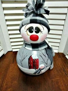 a ceramic snowman sitting on top of a wooden floor