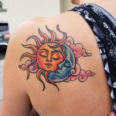 a woman with a sun and moon tattoo on her upper arm, behind her back