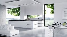 a modern kitchen with white furniture and large windows