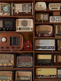 many old radio's are stacked on top of each other