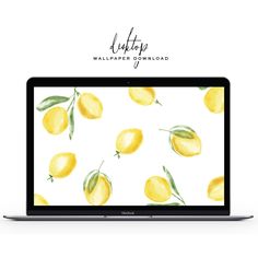 an open laptop computer sitting on top of a white surface with lemons painted on it