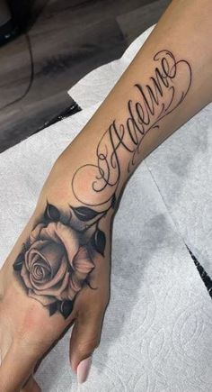 a woman's hand with a rose tattoo and the word welcome written on it