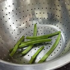 some green beans are in a metal bowl