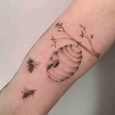 a tattoo on the arm with bees flying around it and a tree branch in the middle