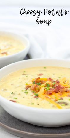 two bowls of cheese potato soup with bacon and chives in them on a plate