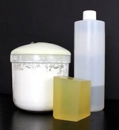 two soaps and a container sitting on a table next to each other, one with a bar of soap in it