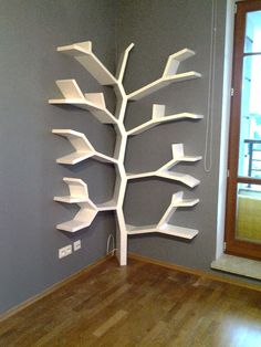 a white tree shelf sitting on top of a hard wood floor