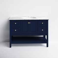 a bathroom vanity with a marble top and blue cabinetry, against a white wall