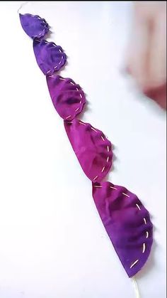 three purple and white pieces of glass sitting on top of a table