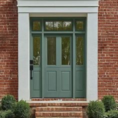 a green front door on a brick building