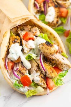 chicken falafel wrap with lettuce, tomatoes and onions on it