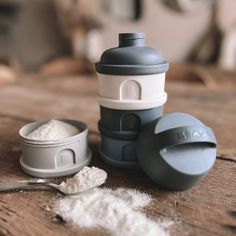 a wooden table topped with lots of white powder next to a cup and spoon on top of it