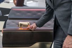 a man in a suit and tie standing next to a large piece of luggage