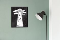 a black and white poster hanging on the side of a wall next to a lamp