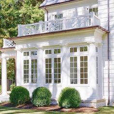 a white house with two balconies and three windows