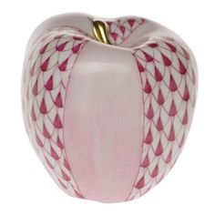 a pink and white apple with gold decoration on it's side, sitting in front of a white background