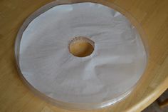 a round table with a clear plastic cover on it's edge and a hole in the middle