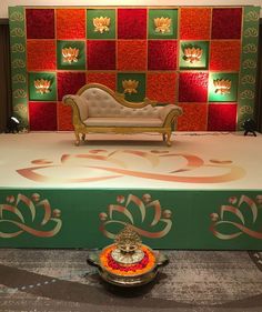 a stage set up with a couch and flower arrangement