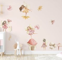 a child's room with pink walls and fairy wall decals on the wall