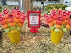 there are some fruit in small cups on the kitchen counter with stop signs attached to them