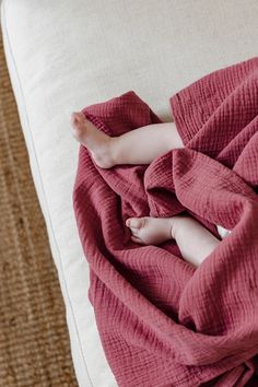 a baby wrapped in a blanket on top of a bed