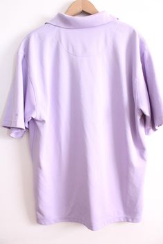 "Pastel lilac colored polo shirt with buttons at the top and loose fit. Ideal 90s basic in good condition. 'Grand Master Golf' brand 100% Polyester Size L Measures: 30\" length 23\" across chest 10\" sleeve 3.5\" tall collar B-3" Oversized Purple Collared Top, Casual Purple Cotton Polo Shirt, Casual Purple Short Sleeve Polo Shirt, Oversized Lavender Cotton Top, Oversized Lavender Casual Top, Purple Casual Polo Collar Shirt, 90s Style Purple Short Sleeve Tops, Purple Short Sleeve 90s Tops, Casual Purple Polo Collar Shirt