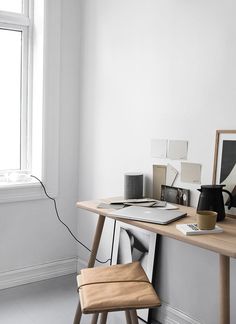 a wooden desk topped with a laptop computer next to a window and a lamp on top of it