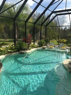 an indoor swimming pool surrounded by plants and trees