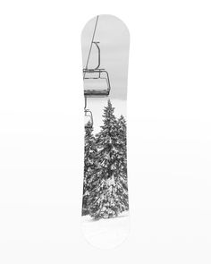 a snowboard with a ski lift going over it and trees in the foreground