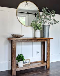 a potted plant sitting on top of a wooden table in front of a mirror