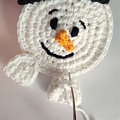 a crocheted snowman is hanging on the wall