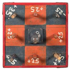 an old checkerboard game with numbers and symbols painted on the board, including two knobs