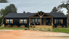 a black house with two front porches and steps leading up to the front door