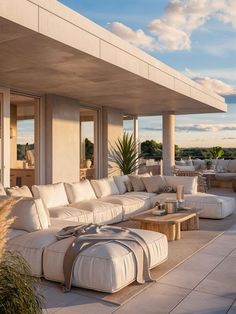 an outdoor living area with white furniture and large windows