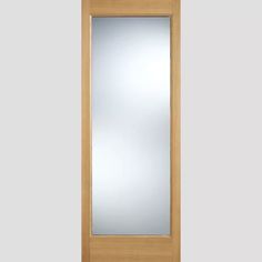 a wooden door with a glass paneled in to the side and mirror above it