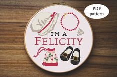 i'm a pelicity cross stitch pattern in the hoop on a wooden surface