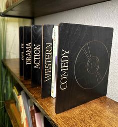 three books are sitting on a shelf in front of a book case with the words comedy written on it