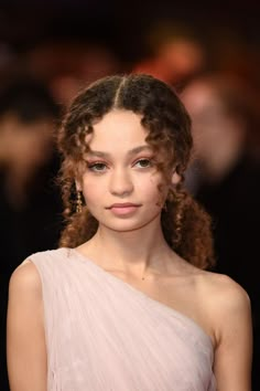 a close up of a person wearing a dress with braids on her head and shoulder