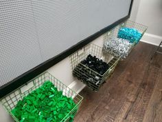 two baskets filled with green and blue legos sitting on the floor next to each other