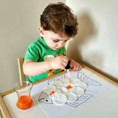 a little boy that is sitting at a table with some food in front of him