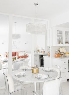 a white kitchen and dining room are shown