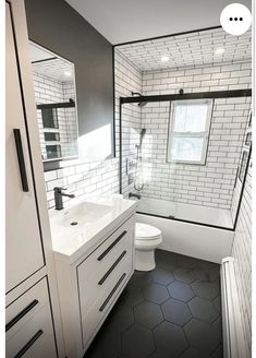 a bathroom with black and white tiles on the walls