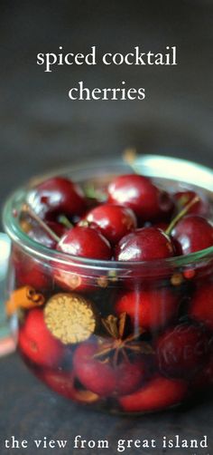 a glass jar filled with cherries on top of a table